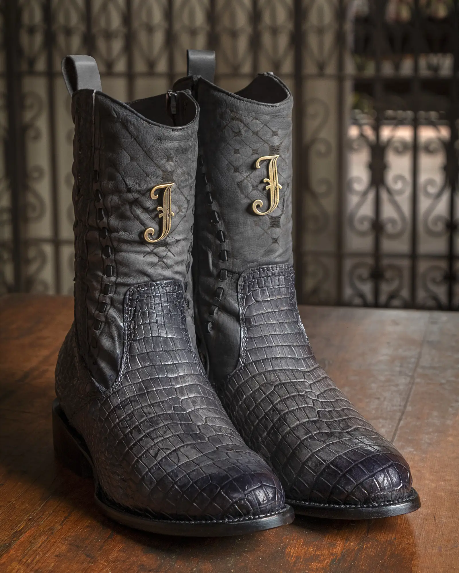 Par de botas Jauregui de piel de cocodrilo negra con monograma en la caña